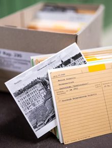 Karteikarte mit historischem Foto, im Hintergrund ein Karteikasten